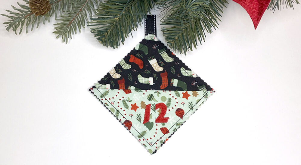 Sew a fun and unique countdown to Christmas calendar with Mary Mulari’s Treasure Pockets project from her Adventures with 5-inch Fabric Squares book! Each pocket features a hanging loop and front pocket – an ideal space for applique number